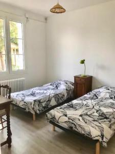 two beds sitting next to each other in a room at Hebergements le Camp d'Auneau - Leboudubout in Auneau