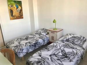 1 dormitorio con 2 camas, mesa y una foto en Hebergements le Camp d'Auneau - Leboudubout, en Auneau