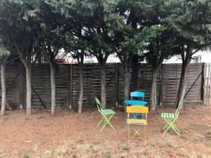 dos sillas y una mesa en un patio con árboles en Hebergements le Camp d'Auneau - Leboudubout, en Auneau