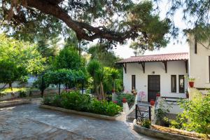 uma casa com um jardim em frente em ILIOCHARI sea view apartments Oropos - Kalamos em Kalamos