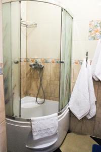 W łazience znajduje się prysznic ze szklanymi drzwiami. w obiekcie Берізка w mieście Voznesensk
