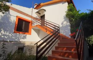 Un escalier mène à une maison blanche aux accents orange. dans l'établissement Ina 2, à Funtana