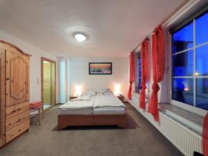 een slaapkamer met een bed en 2 ramen bij Haus Marianne in Schafstedt
