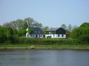 uma casa situada nas margens de um rio em Haus Marianne em Schafstedt