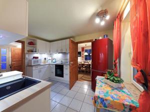 uma cozinha com armários brancos e um frigorífico vermelho em Haus Marianne em Schafstedt