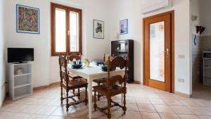 a kitchen with a table and chairs and a television at Welcomely - Isole Apartments in Olbia