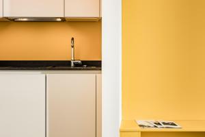 a kitchen with white cabinets and a sink at Apartments Seewinkel in Caldaro