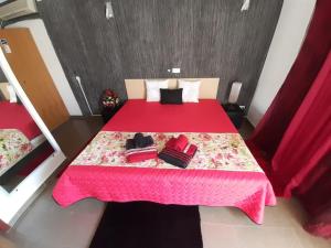 a bedroom with a red bed with a pink blanket at Paraíso D`el Rio in Mértola