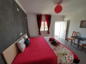 1 dormitorio con 1 cama grande con manta roja en Paraíso D`el Rio, en Mértola