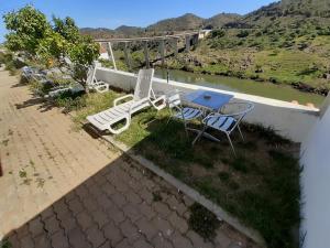 un patio con tavolo e sedie e vista sul fiume di Paraíso D`el Rio a Mértola