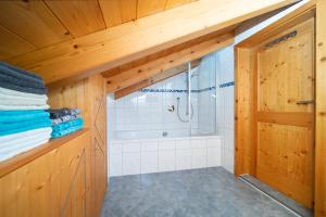 ein Badezimmer mit Dusche und Holzdecke in der Unterkunft Apartment Anda in Garmisch-Partenkirchen + 13 Fotos
