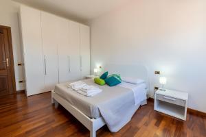 Schlafzimmer mit einem Bett mit blauen und grünen Kissen in der Unterkunft Marysel Rooms in Olbia