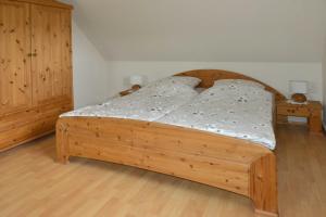 una camera da letto con un letto in legno e un armadio in legno di Ferienwohnung Sonnenberg, 25502 a Weener