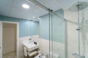 bagno con lavandino e doccia di Arco Macarena Suite a Siviglia