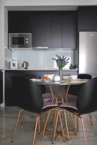 a kitchen with black cabinets and a table with chairs at Arco Macarena Suite in Seville