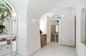 bagno bianco con lavandino e specchio di I Tre Soli Apartments by CapriRooms a Capri