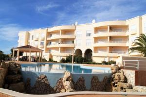 a large building with a swimming pool in front of it at Vila das Acacias in Luz
