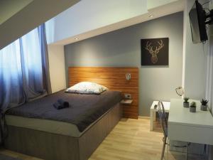 a bedroom with a bed with a wooden headboard at Station Apartments Katowa 11 in Krakow