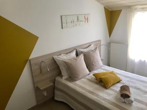 1 dormitorio con 1 cama con sábanas y almohadas blancas en 8 Le Chiron de la Roche 85130 Chanverrie, en La Verrie