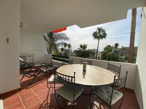 un patio con tavolo e sedie sul balcone. di El Casa Blanca - Golf Resort in La Cala de Mijas a La Cala de Mijas