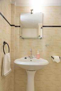 łazienka z umywalką i lustrem w obiekcie ILIOCHARI sea view apartments Oropos - Kalamos w mieście Kalamos +37 zdjęć