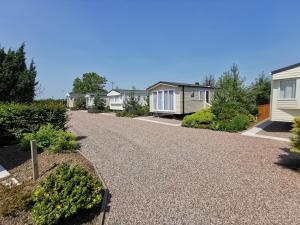 a row of cottages with a gravel driveway at The Trotting Mare Caravan Park - Adults Only in Wrexham