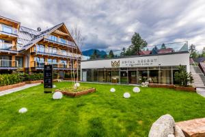 a large building with a lawn in front of it at Apartamenty Royal Resort Spa in Zakopane