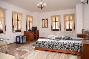 Schlafzimmer mit einem Bett, einem Tisch und Fenstern in der Unterkunft Enchevite Strannopriemnitsi in Slatograd