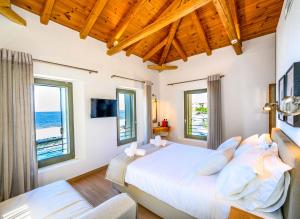 a bedroom with a bed and two windows at Selinitsa Residence Mani in Agios Nikolaos