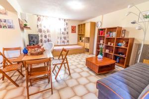 a living room with a bed and a table and chairs at Pine trees apartment in Preveza