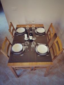 a wooden table with plates and glasses and wine bottles at L’oasi di Cice in Rufina