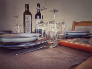 uma mesa com pratos, garrafas de vinho e copos de vinho em L’oasi di Cice em Rufina