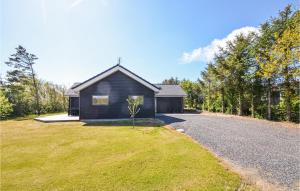 a black house with a gravel driveway at Cozy Home In Vinderup With House Sea View in Vinderup