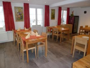 uma sala de jantar com mesas e cadeiras de madeira em Hotel Restaurant Sunnmatt em Aeschi