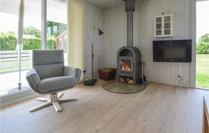uma sala de estar com uma cadeira e uma lareira em Beautiful Home In Hemmet With Kitchen em Hemmet