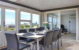 een eetkamer met een tafel, stoelen en ramen bij Amazing Home In Slagelse With Wifi in Slagelse