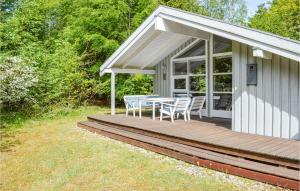 a house with a wooden deck with a table and chairs at 2 Bedroom Lovely Home In Sæby in Sæby