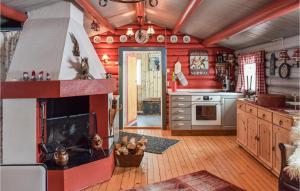 eine Küche mit roten Wänden und einem Kamin in der Unterkunft Sjusjen Brttum in Sjusjøen