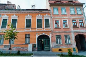 un bâtiment orange avec des portes et des fenêtres vertes dans l'établissement Samuel Wagner, à Sibiu