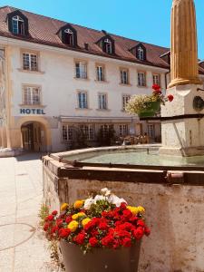 un hotel con flores frente a un edificio en SWISS HOTEL LA COURONNE en Avenches