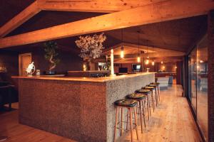 a bar with stools in a room with wooden ceilings at Charm Nature in Azoia