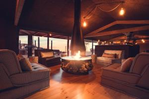 a living room with couches and a fire pit in the middle at Charm Nature in Azoia