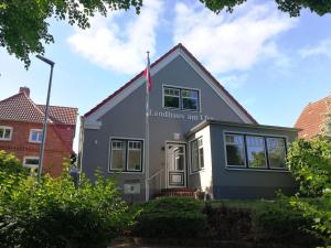ein Haus mit einer Flagge auf der Vorderseite in der Unterkunft Landhaus am Ufer - Wohnung 4 in Heiligenhafen