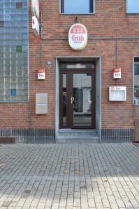 a front door of a brick building with a sign on it at Pension Zur Traube in Bergheim