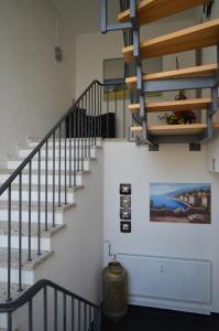 eine Treppe in einem Haus mit einem Gemälde an der Wand in der Unterkunft Pension Zur Traube in Bergheim