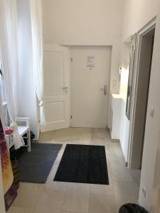 un pasillo con una puerta blanca y una alfombra negra en PULSE OF VIENNA by JR City Apartments, en Viena
