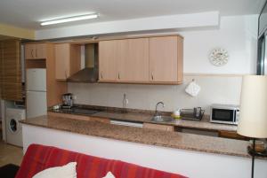 a kitchen with wooden cabinets and a counter top at Apartamento Deltebre in Deltebre