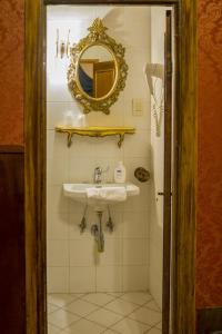 ein Bad mit einem Waschbecken und einem Wandspiegel in der Unterkunft Hotel Abaco in Florenz