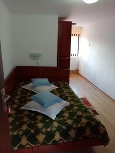 1 dormitorio con 1 cama con 4 almohadas en Pensiunea Sebastian, en Buşteni