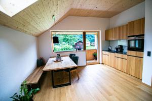 a kitchen with a wooden table and a large window at hus56 in Mellau